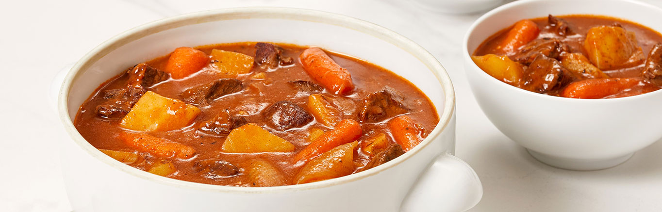 An image of prepared Slow Cooker Hearty Beef Stew made with beef, potatoes, carrots, onions, garlic, Swanson® Beef Broth or Stock and peas.