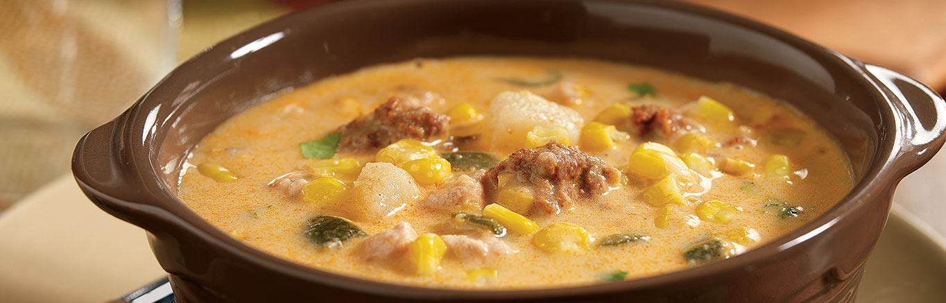 An image of prepared Slow Cooker Poblano Corn Chowder with Chicken and Chorizo made with Swanson® Chicken Broth, canned cream style corn, potato, poblano chiles, corn, chicken, chorizo sausage, cream and cilantro.