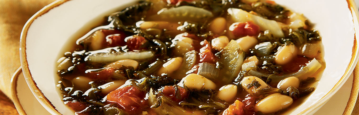 An image of prepared Slow Cooker White Bean with Fennel Soup made with Swanson® Vegetable Broth, fennel, onion, garlic, frozen spinach, diced tomatoes and cannellini beans.