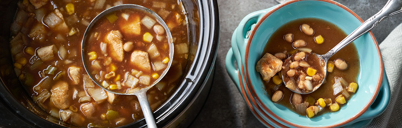 An image of prepared Slow Cooked Southwestern Chicken & White Bean Soup made with chicken, Swanson® Chicken Broth, Pace® Picante Sauce, garlic, cumin, navy beans, corn and onion.