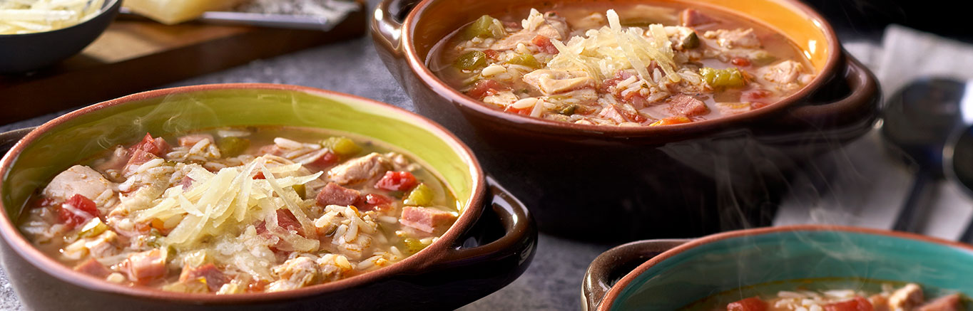 An image of prepared Slow Cooker Chicken Asopao with Smoked Ham and Manchego Cheese made with Swanson® Natural Goodness® Chicken Broth, onion, green bell pepper, diced tomatoes with green chiles, chicken, ham, rice and manchego cheese.