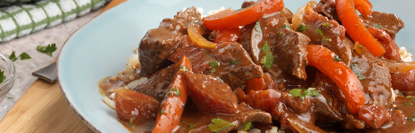 An image of Spanish Beef made with Swanson® Beef Stock, chili powder, cumin, beef sirloin steak, onion, red bell pepper, canned diced tomatoes and cilantro.