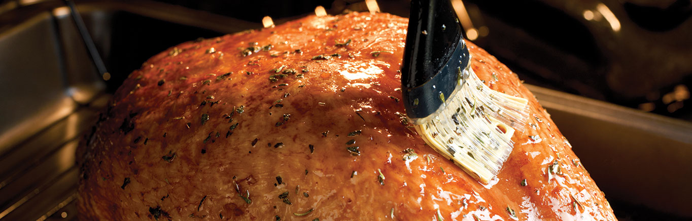 An image of prepared Turkey with Herb Basting Sauce made with Swanson® Chicken Stock, lemon juice, basil, thyme, black pepper and bone in turkey breast.