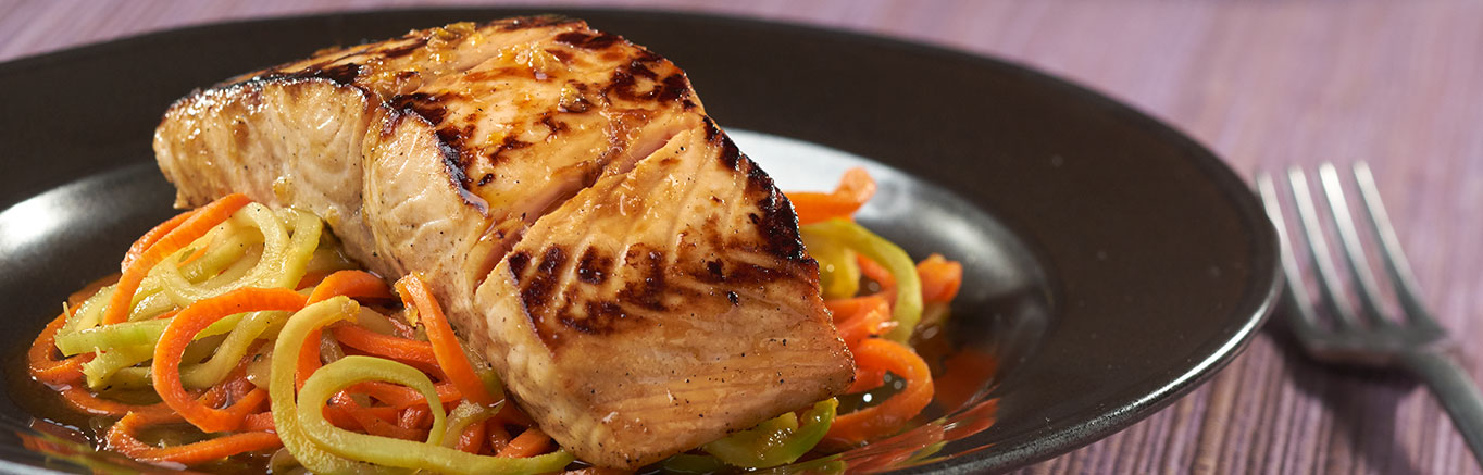 An image of prepared Teriyaki Salmon over Sesame Broccoli Noodles made with soy sauce, honey, sesame oil, salmon, broccoli, carrot and Swanson® Vegetable Broth.