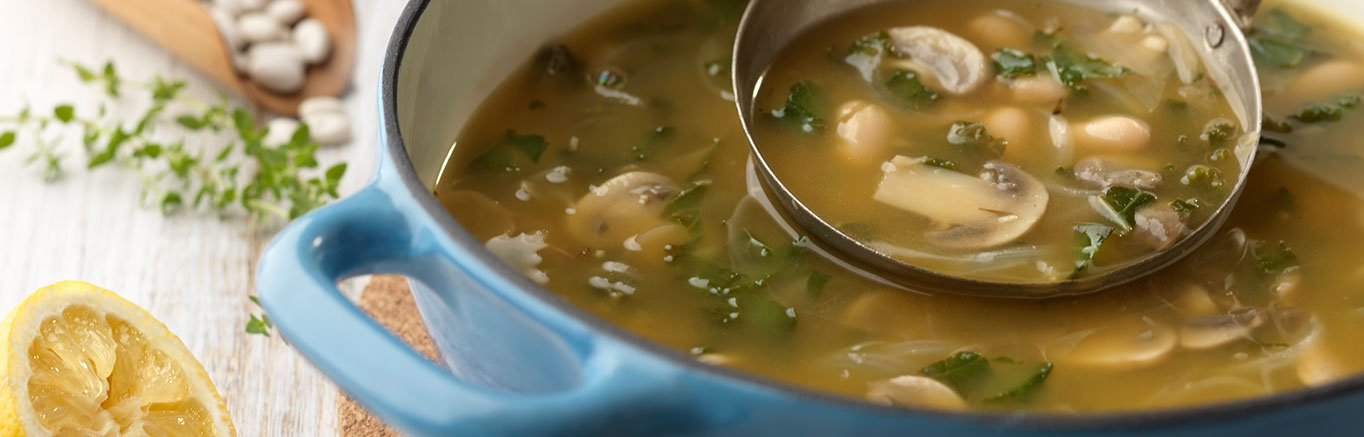 An image of prepared White Bean, Lemon & Kale Soup made with onion, garlic, kale, mushrooms, Swanson® Vegetable Broth, cannellini beans and lemon juice.