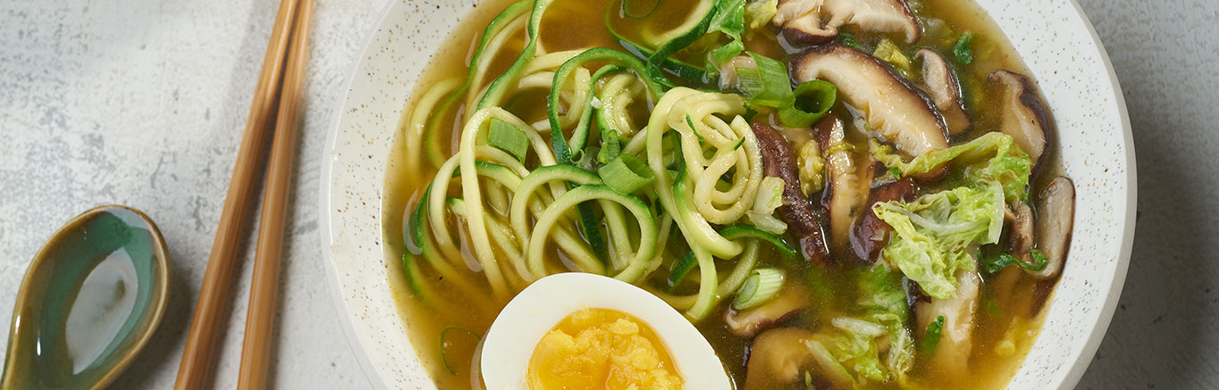 An image of prepared Zoodle Ramen made with shiitake mushrooms, napa cabbage, miso, Swanson® Vegetable Broth, zucchini noodles, scallions, red cabbage and hard cooked eggs.