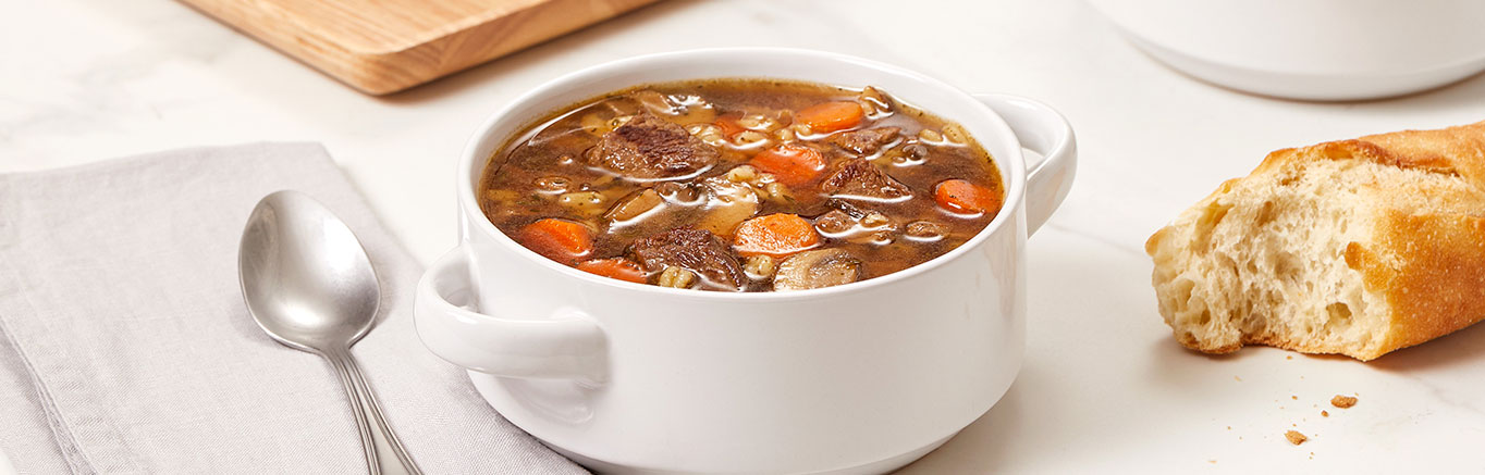 An image of prepared Beef Barley Soup made with barley, sirloin steak, mushrooms, Swanson® Beef Broth and carrots.