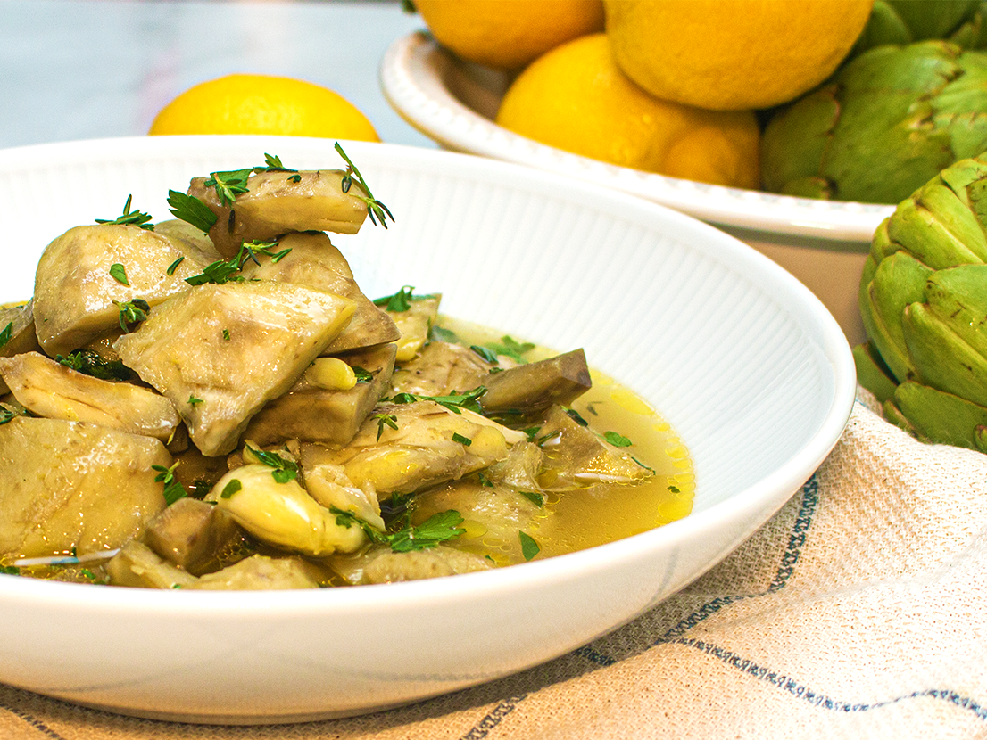 An image of prepared Braised Artichokes with White Wine and Herbs made with Swanson® Chicken Broth, white wine and artichokes.