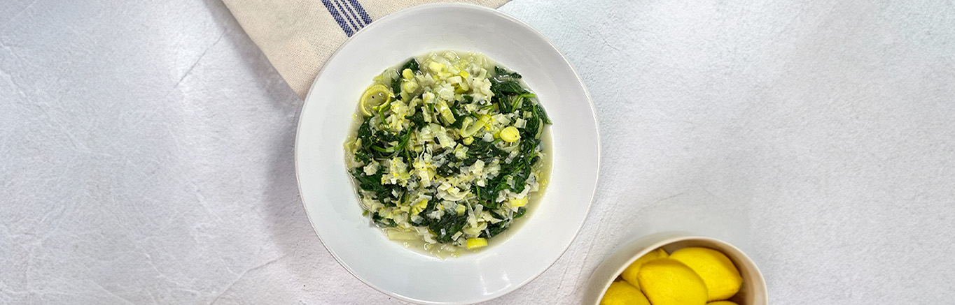 An image of prepared Braised Leeks and Fresh Spinach with Feta and Lemon made with leeks, Swanson® Chicken Broth, spinach and feta.