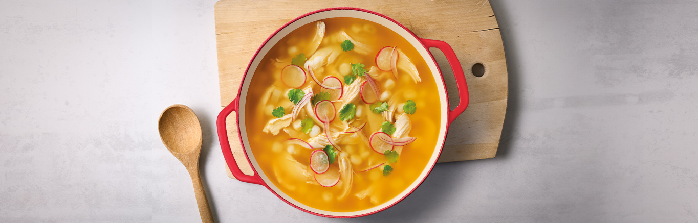 An image of prepared Quick Cilantro Lime Chicken Pozole made with onion, garlic, Swanson® Spicy Chicken Broth, hominy, chicken, cilantro, green cabbage and radish.