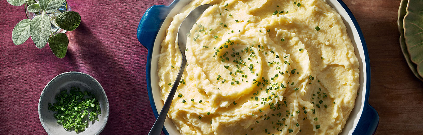 An image of prepared Sour Cream & Chive Mashed Potatoes made with Swanson® Chicken Broth, potatoes, light cream or half and half, sour cream, butter and chives.