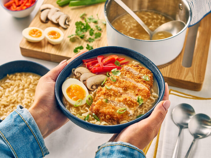 An image of prepared Katsu Ramen made with panko, chicken, Swanson® Ramen Chicken Broth, coconut milk, ramen noodles and jammy eggs.