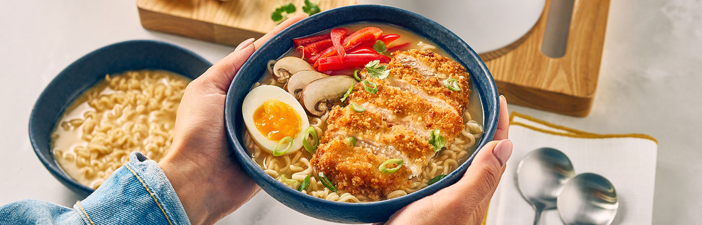 An image of prepared Katsu Ramen made with panko, chicken, Swanson® Ramen Chicken Broth, coconut milk, ramen noodles and jammy eggs.