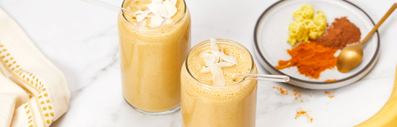 An image of prepared Plant-Based Golden Milk Smoothie made with V8® Peach Mango 100% Fruit and Vegetable Juice, oats, coconut milk and banana.