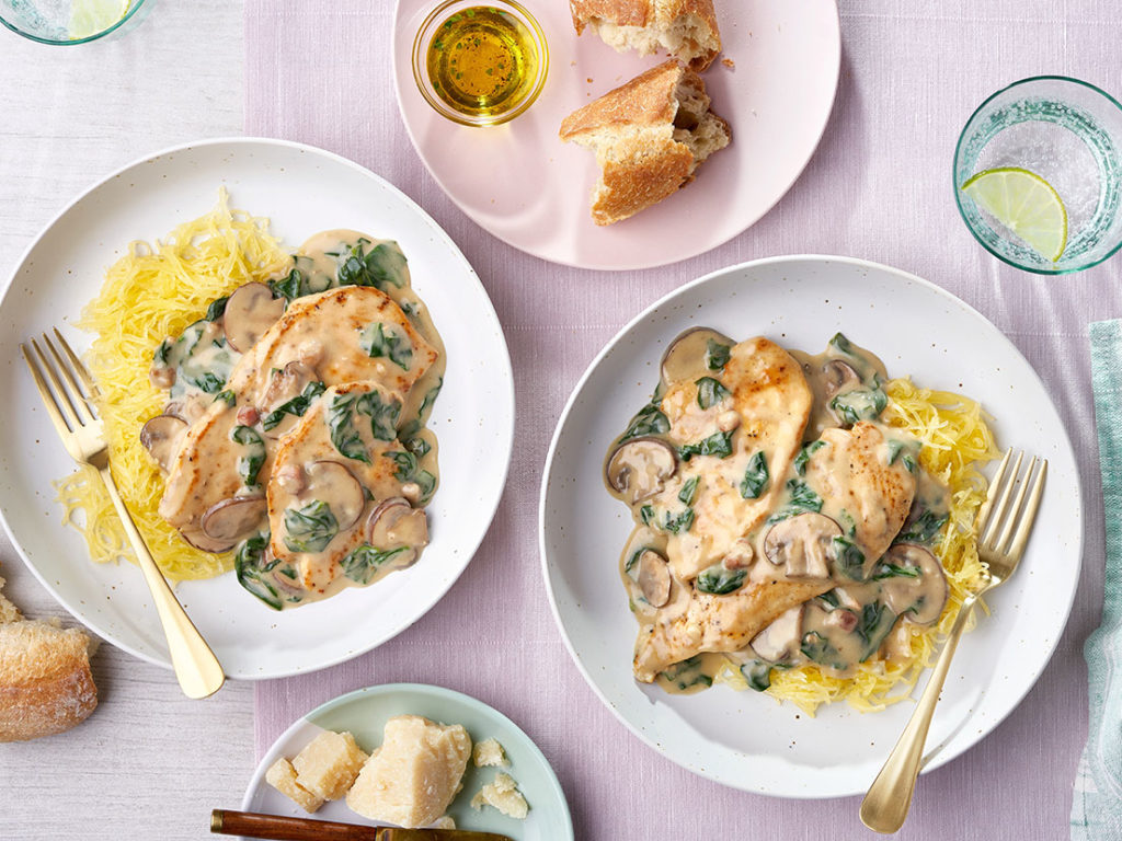 An image of prepared Big Batch Creamy Garlic Parmesan Chicken showing chicken breast, pancetta or bacon, cremini mushrooms, baby spinach Unsalted Campbell's® Cream of Chicken Soup, Swanson® Unsalted Chicken Broth or Stock, Parmesan cheese and lemon juice.