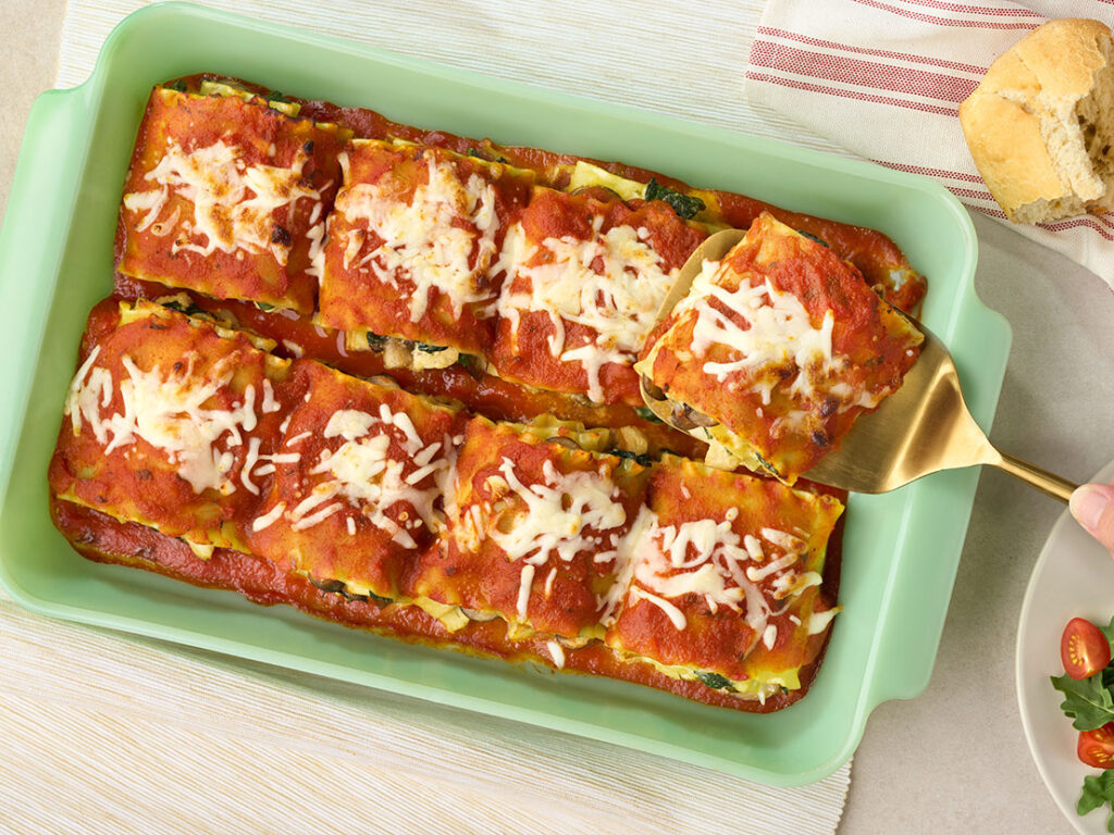 An image of prepared Spinach Lasagna Roll-Ups using lasagna noodles, Big Batch Creamy Garlic Parmesan Chicken, ricotta cheese, mozzarella cheese and Prego® Traditional Lower Sodium Pasta Sauce.