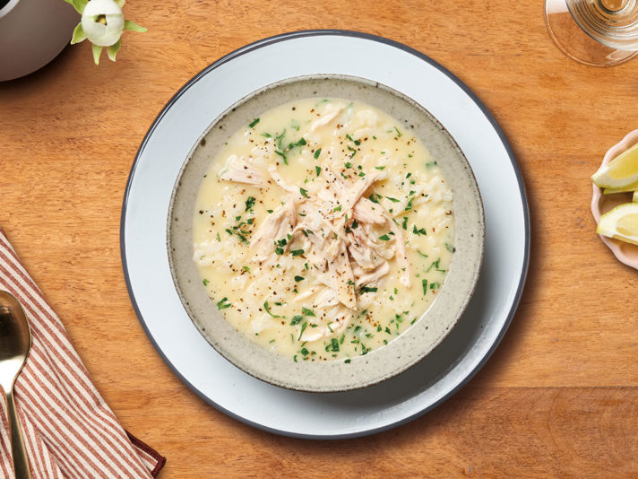 An image of prepared Greek Lemon Chicken & Rice Soup showing a soup made with Swanson® Unsalted Chicken Broth, Campbell's® Condensed Cream of Chicken Soup, chicken, white rice, lemon juice and parsley.