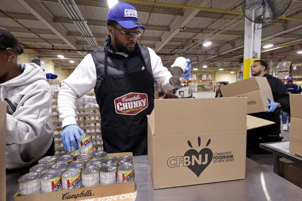 Photo of New York Giants outside linebacker, Kayvon Thibodeaux with his mother, Shawnta, on Tuesday, Oct. 04, 2022 at the Community FoodBank of New Jersey with Campbell's Chunky. Kayvon, the NY Giants and Chunky donated 100,000 meals towards the brand's community program, Chunky Sacks Hunger. (Adam Hunger/AP Images for Campbell's Chunky)