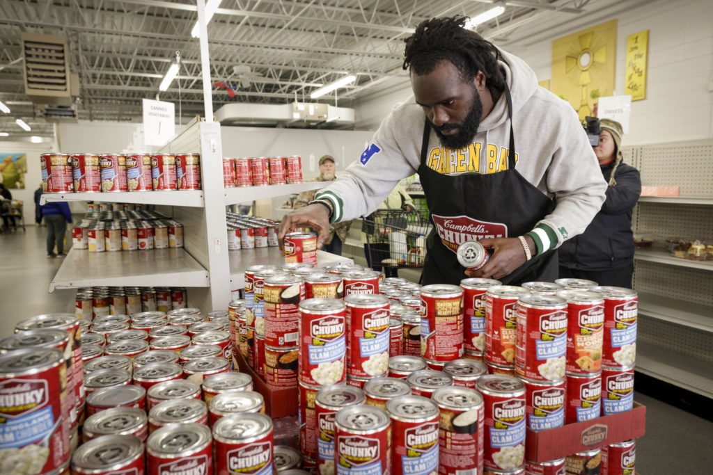Green Bay Packers linebacker De'Vondre Campbell stocks shelves at Pauls Pantry, a Green Bay, Wisconsin food pantry on Tuesday, Oct. 18, 2022 in Green Bay with Campbells Chunky. DeVondre, the Packers and Chunky donated 5,000 products today to Pauls Pantry, as part of the brands community program, Chunky Sacks Hunger. (Mike Roemer/AP Images for Campbell's Chunky)