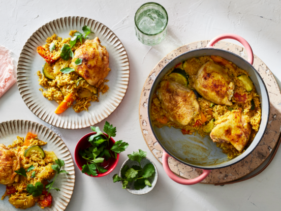 An image of prepared Mediterranean Chicken Thighs with Basmati Rice made with bone-in chicken thighs, onion, bell pepper, zucchini, basmati rice, Swanson® Unsalted Chicken Stock, Campbell's® Condensed Cream of Chicken Soup, cherry tomatoes and spices.
