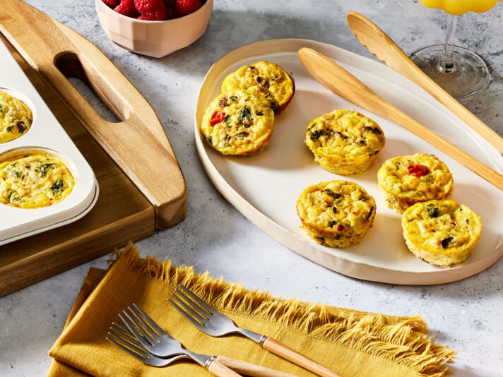 An image of prepared Veggie Egg Bites made with eggs, Campbell's® Condensed Broccoli Cheese Soup, mushrooms, onion, spinach, tomato and feta cheese.