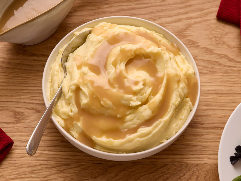 An image of prepared mashed potatoes with Campbell's® Turkey Gravy on top.